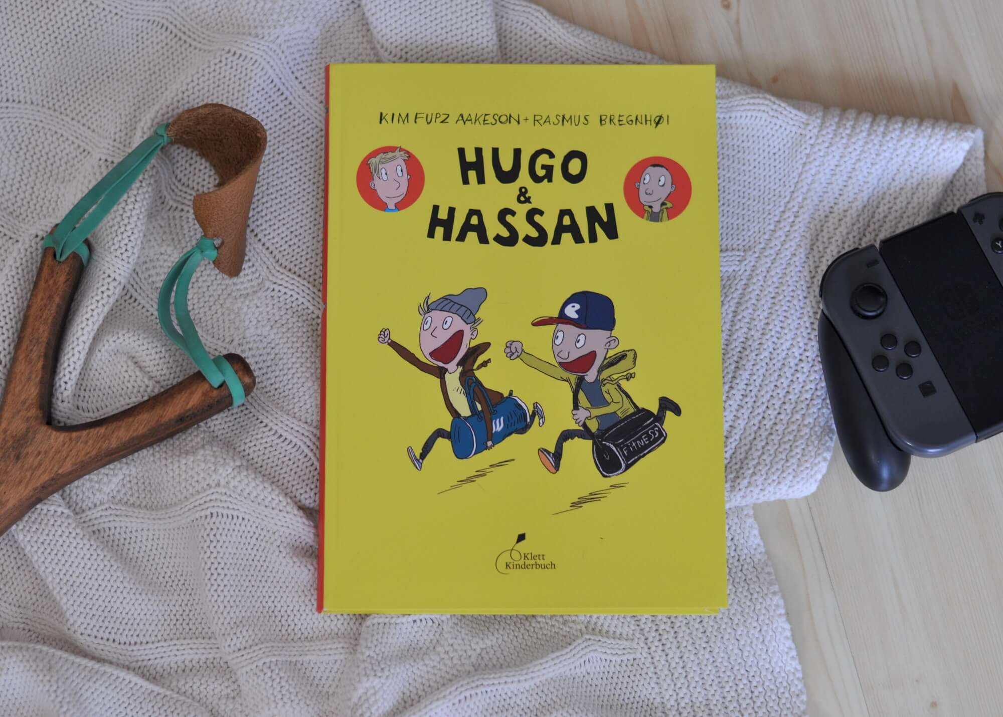 Als Hugo und Hassan an einem öden Nachmittag zum ersten Mal im Hinterhof aufeinandertreffen, stehen sie erst einmal wie zwei Cowboys gegenüber und vermöbeln sich fast. Trotzdem sind sie ab sofort fast unzertrennlich. Denn Hugo und Hassan sind auf einer Wellenlinie. Sie lieben Fußball, Computerspiele und Arschbomben im Schwimmbad. #comic #freundschaft #jungs #zocken #fußball #kloppen #streit #freunde #lesen #kidnerbuch