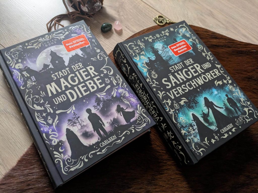 Als Taschendieb hat Cor bisher in seinem Leben wenig Freundlichkeiten und Güte erfahren. Vor allem nicht, nachdem er von der Polizei geschnappt und verurteilt wurde! Doch als er als Arbeitssklave an einen Magier verkauft wird, beginnt für Cor ein neues Leben: Er hilft nicht nur bei den Ermittlungen rund um Diebstähle und Morde, sondern erhält selbst Unterricht in Magie. Schon bald kommt Cor mit Hilfe seiner Zauber und seinem Wissen über die Diebesgilde den Tätern auf die Spur. Doch schafft er es auch, seine Freundin Ro vor den Gefahren in der Stadt zu beschützen und seinen entführten Meister zu retten? "Stadt der Magier und Diebe" von Judith Mohr ist der Auftakt einer fantastischen Krimi-Dilogie voller Herzenswärme und Freundschaft. Ein absolutes Lesehighlight ab 12 Jahren.