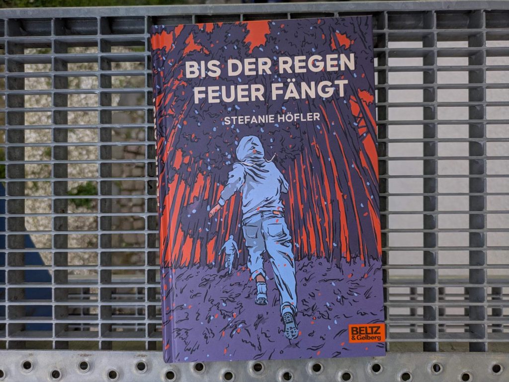 Erst verschwindet ihr Bruder, dann taucht die geheimnisvolle Sol auf und verdreht ihr ganz schön den Kopf. Auf einmal stellt die 16-Jährige Tonia alles infrage: Rudis Verhalten vor seinem Verschwinden, die geistige Abwesenheit ihrer Mutter, ihre eigenen Gefühle, aber vor allem das System der Überwachung, in dem sie lebt. Als sie ohne Sensor und Handy in den Wald flieht, findet sie dort nicht nur unverhoffte Verbündetet, sondern auch Antworten, wie alles miteinander zusammenhängt. "Bis der Regen Feuer fängt" von Stefanie Höfler ist ein aufwühlender Roman um ein Mädchen, das vor Neugierde brennt und endlich weiß, wofür es sich zu kämpfen lohnt.